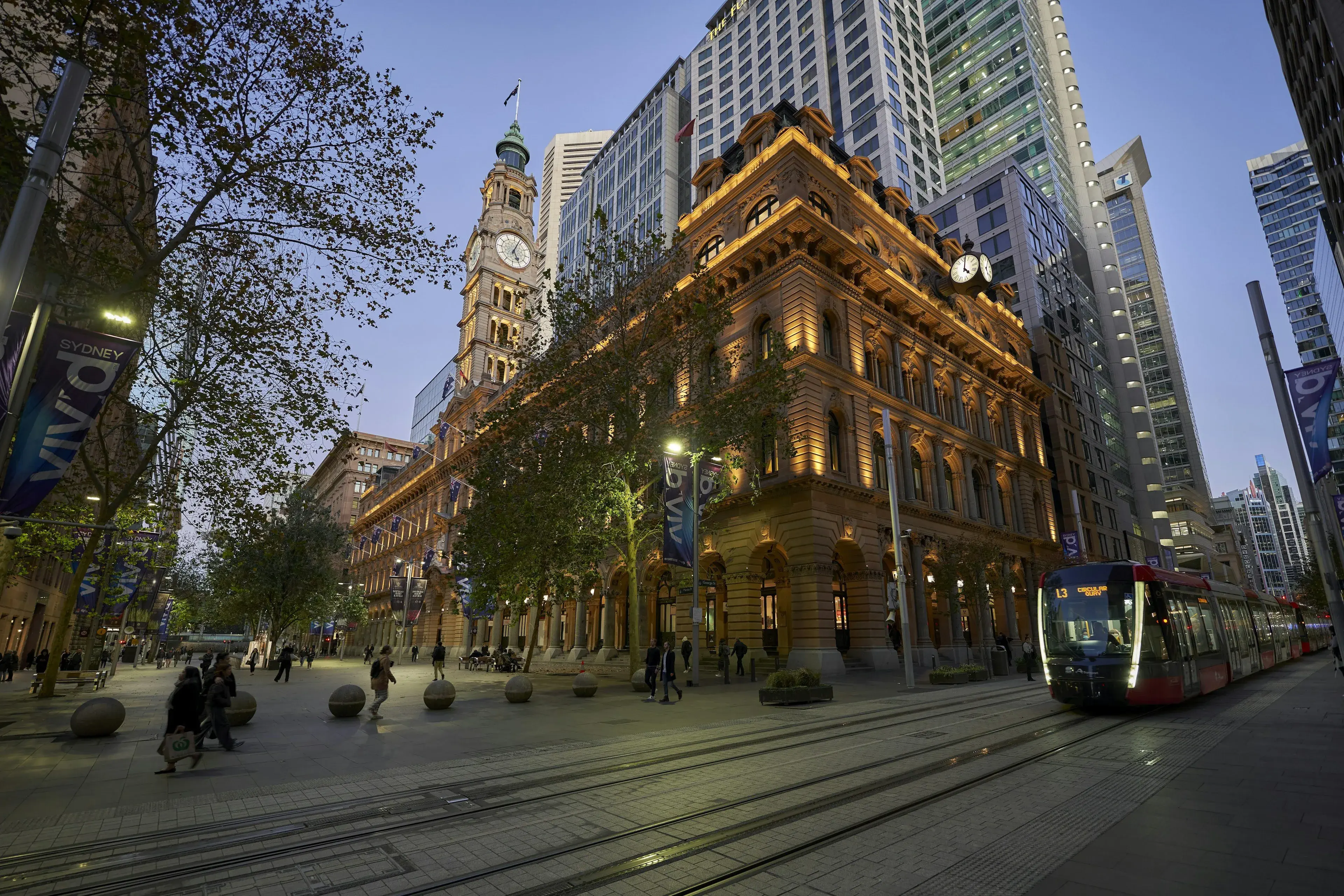 Light rail passing a sandstone heritage building in the Sydney CBD