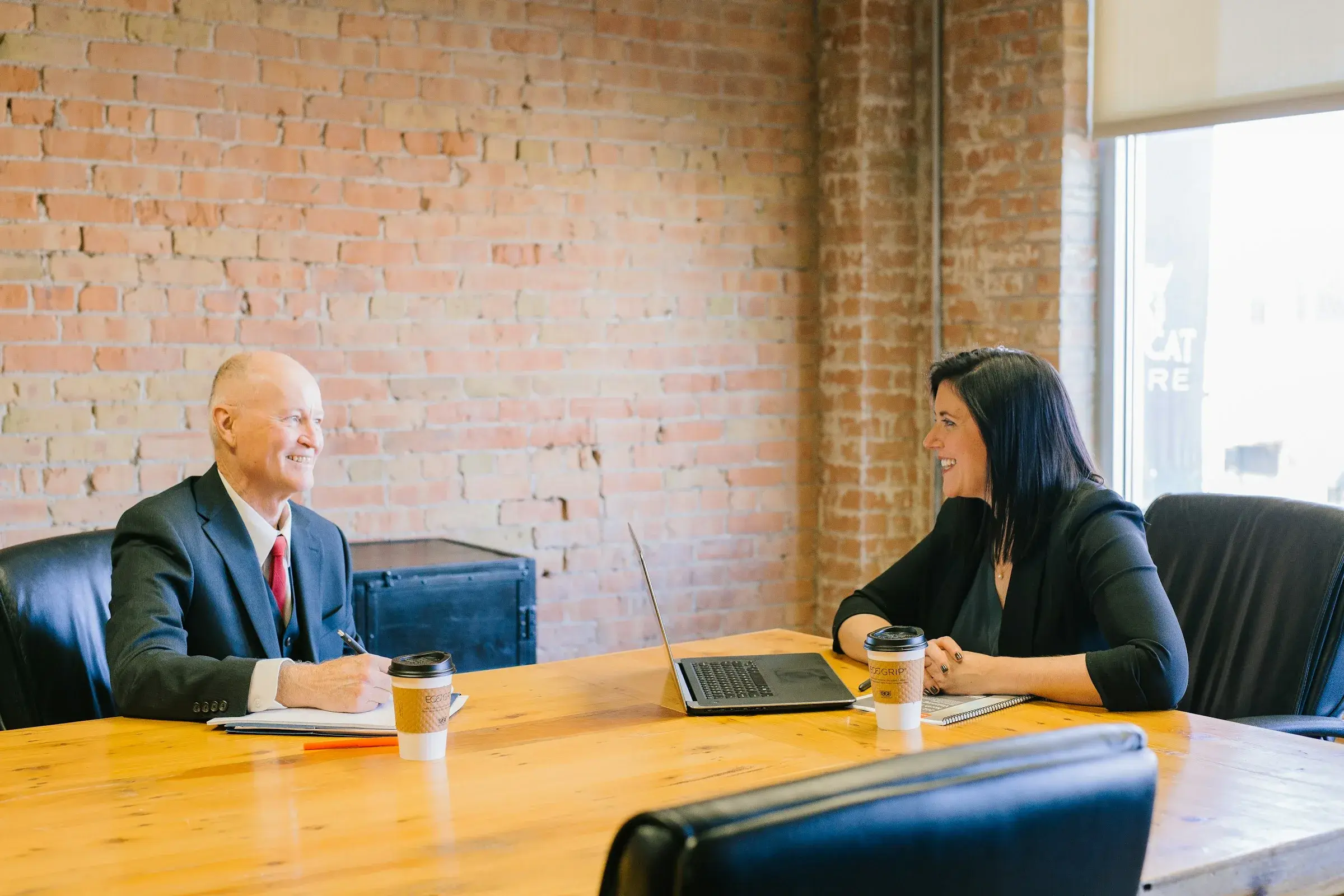 A professional meeting with a client across a table in an office