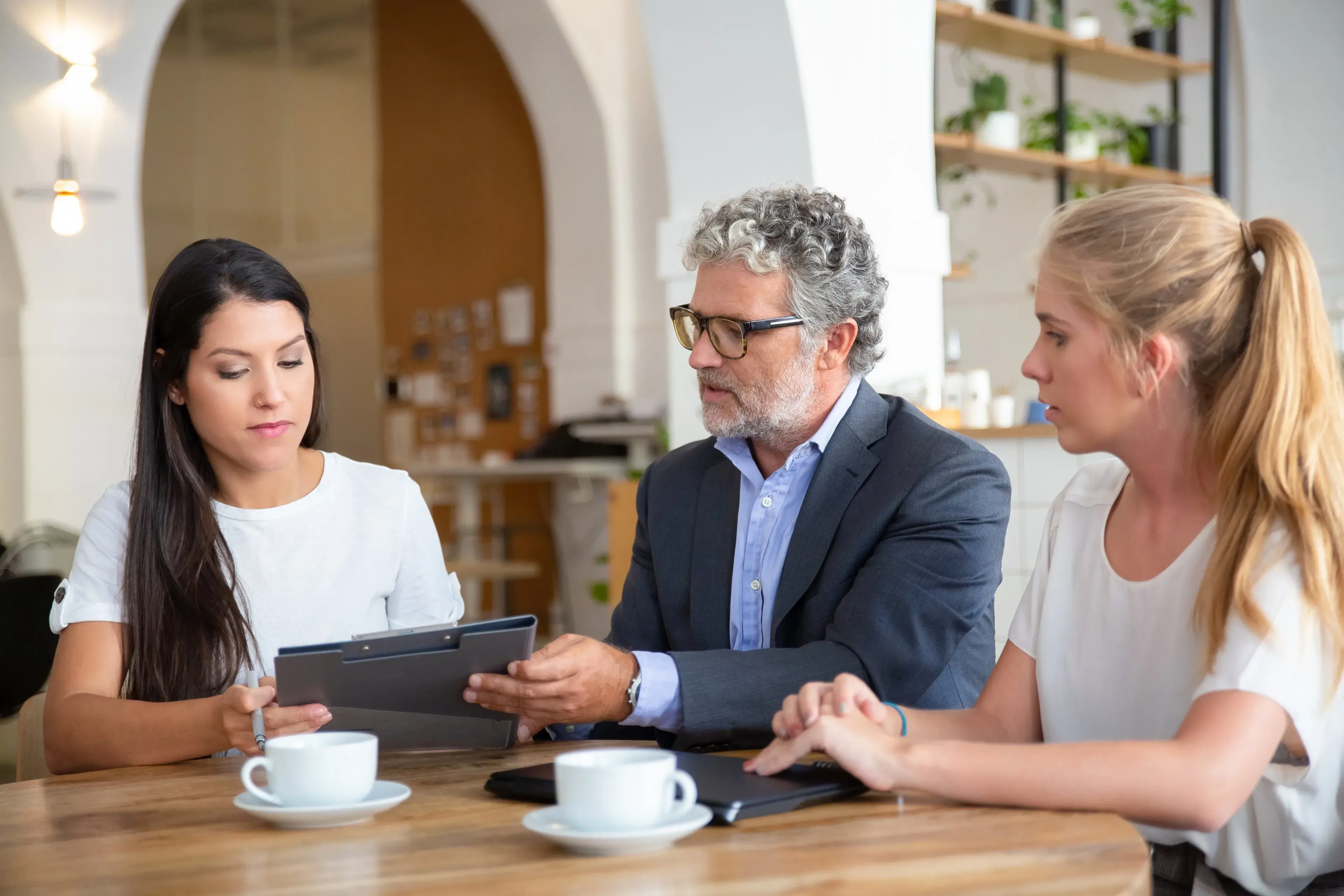 A professional talking through details with two clients over coffee
