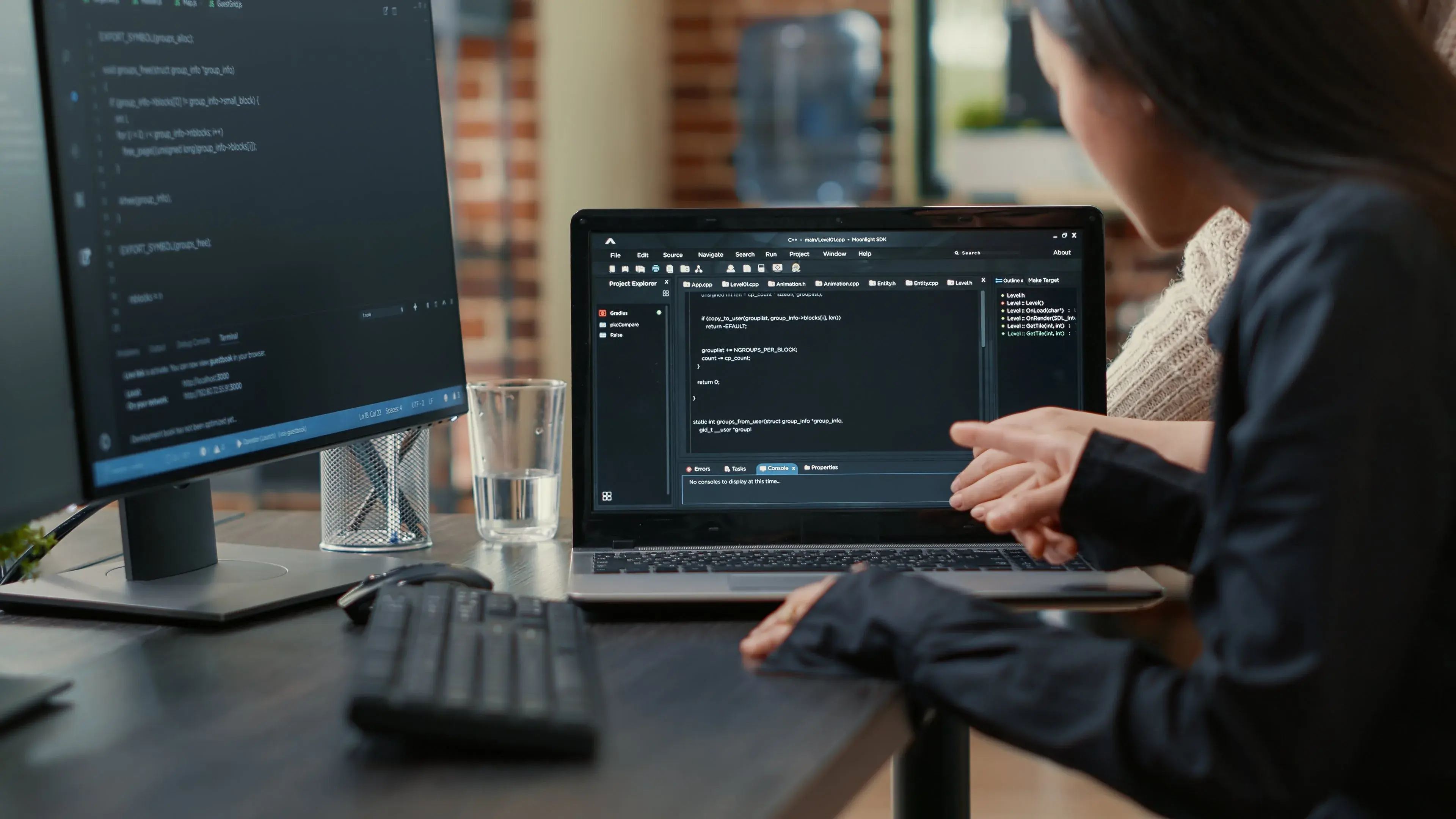 Two developers reviewing code on a laptop at a desk