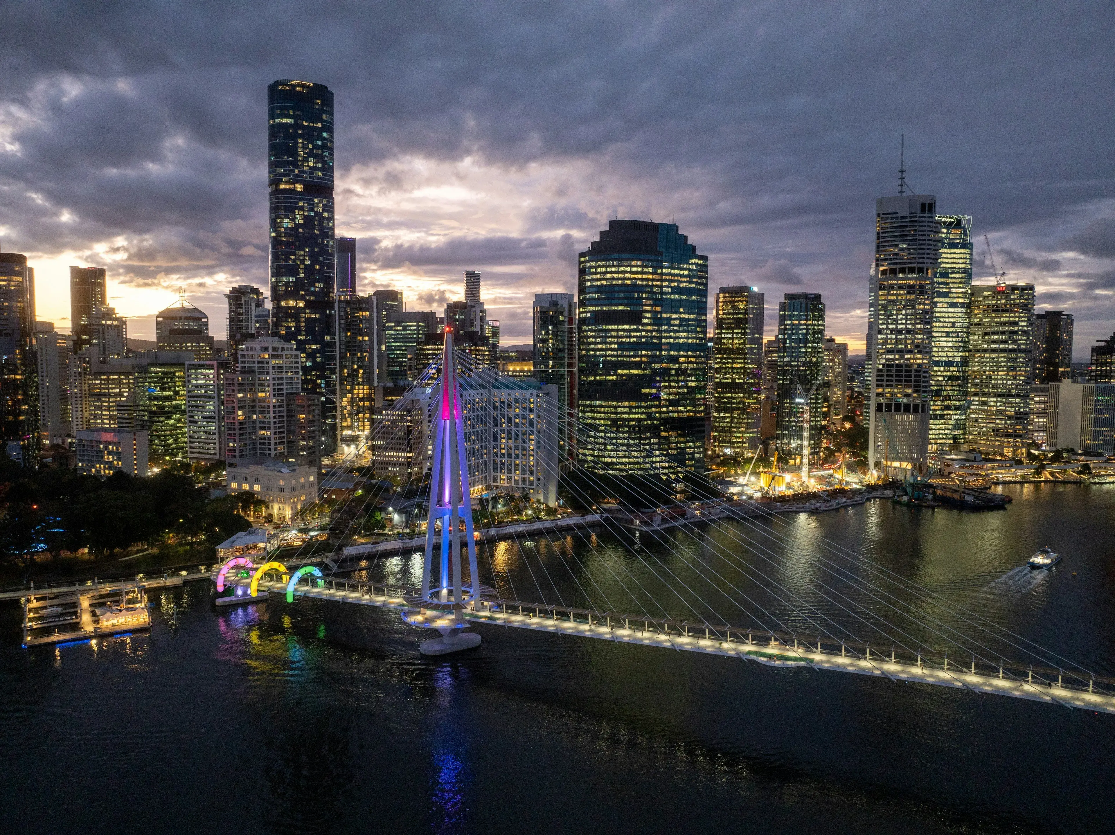 Brisbane skyline and an illuminated footbridge at dusk