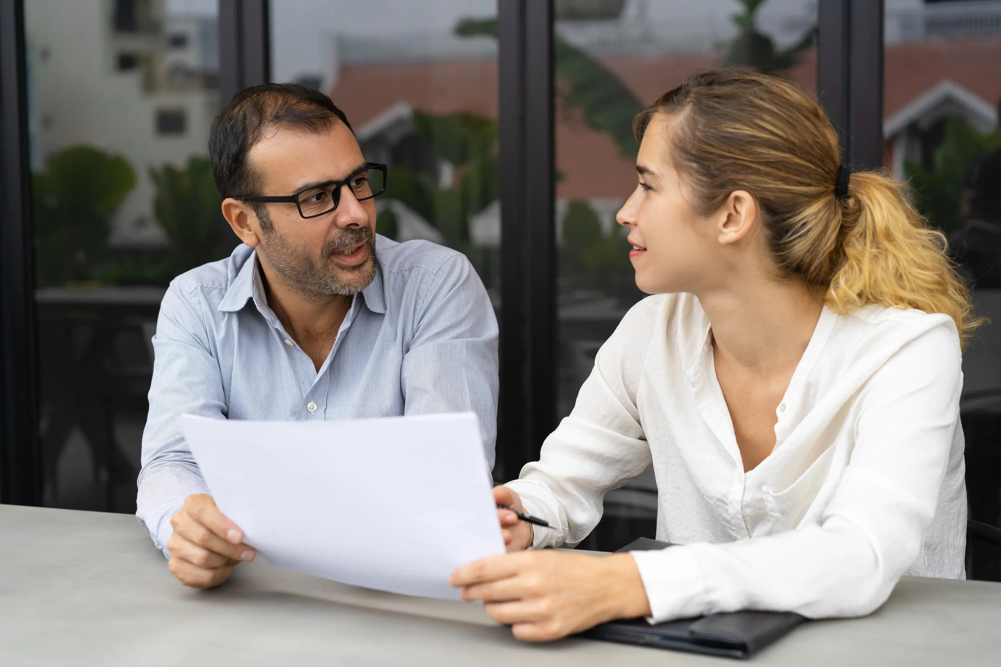 A client and a professional discussing paperwork at a table