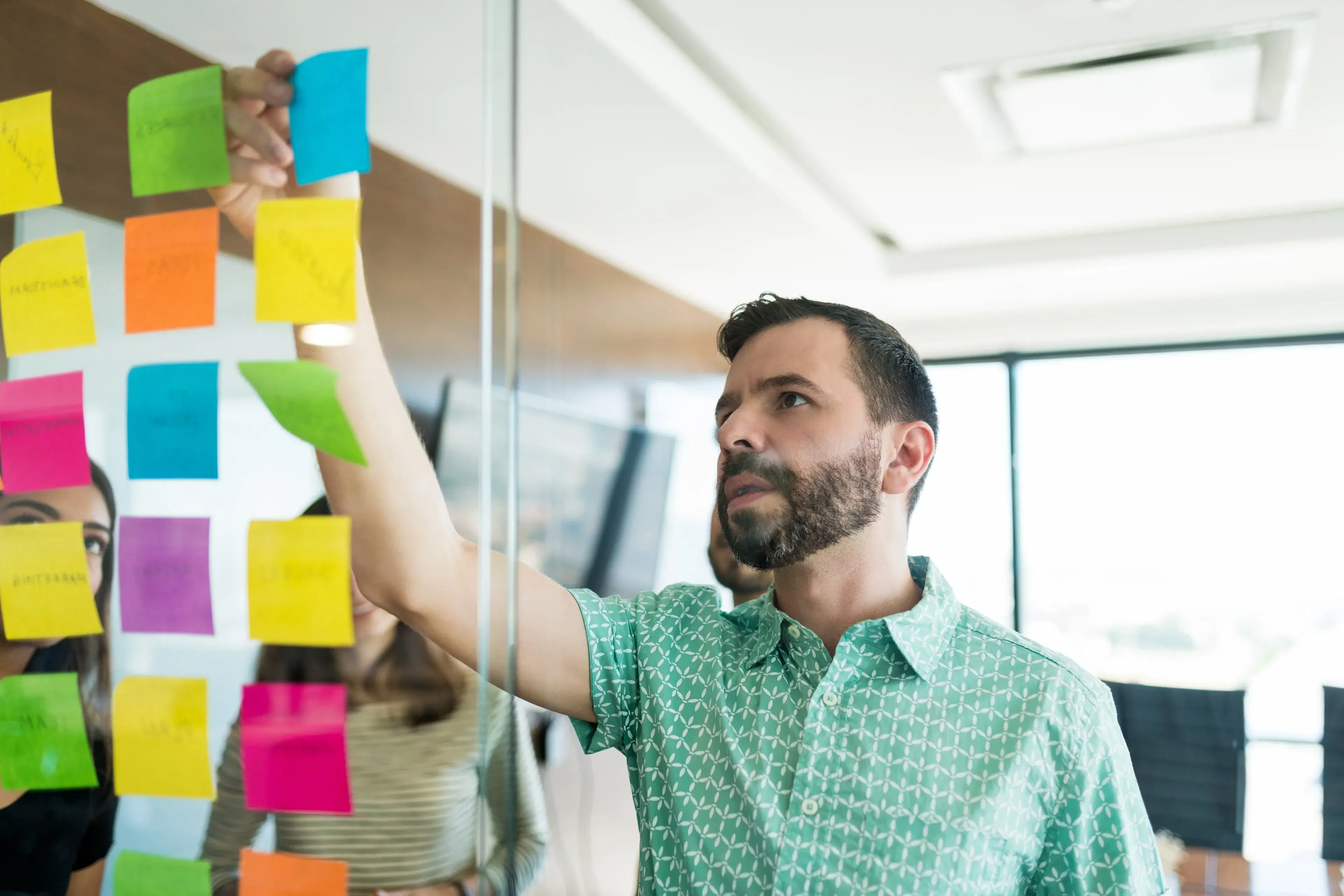 A team planning work with sticky notes on a glass wall